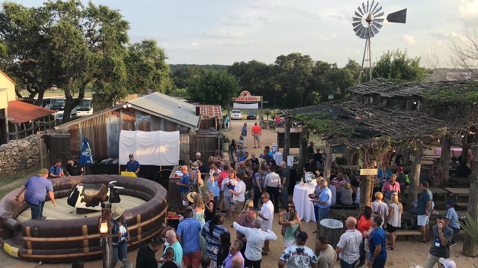 a rodeo with people walking around and chatting