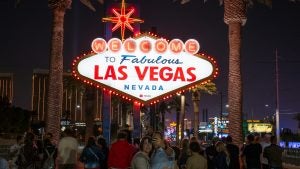 group of people taking selfies at the welcome to las vegas sign
