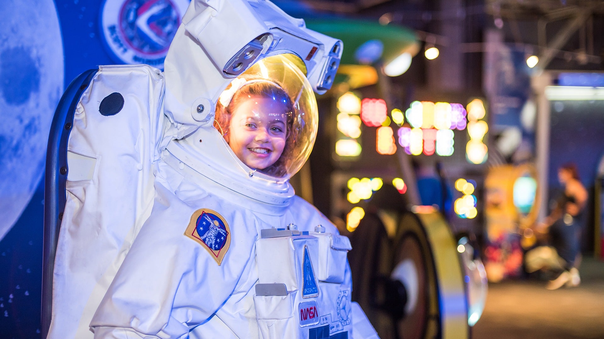 a little girl grinning while wearing an astronaut costume
