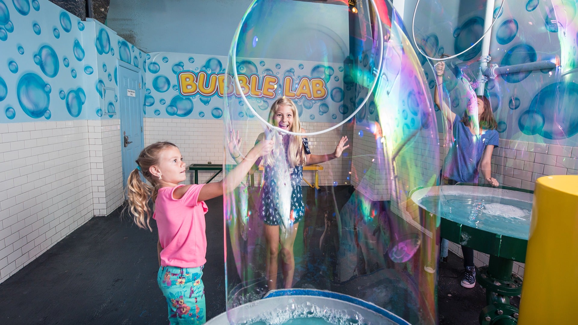 little girls playing in a bubble room with soap
