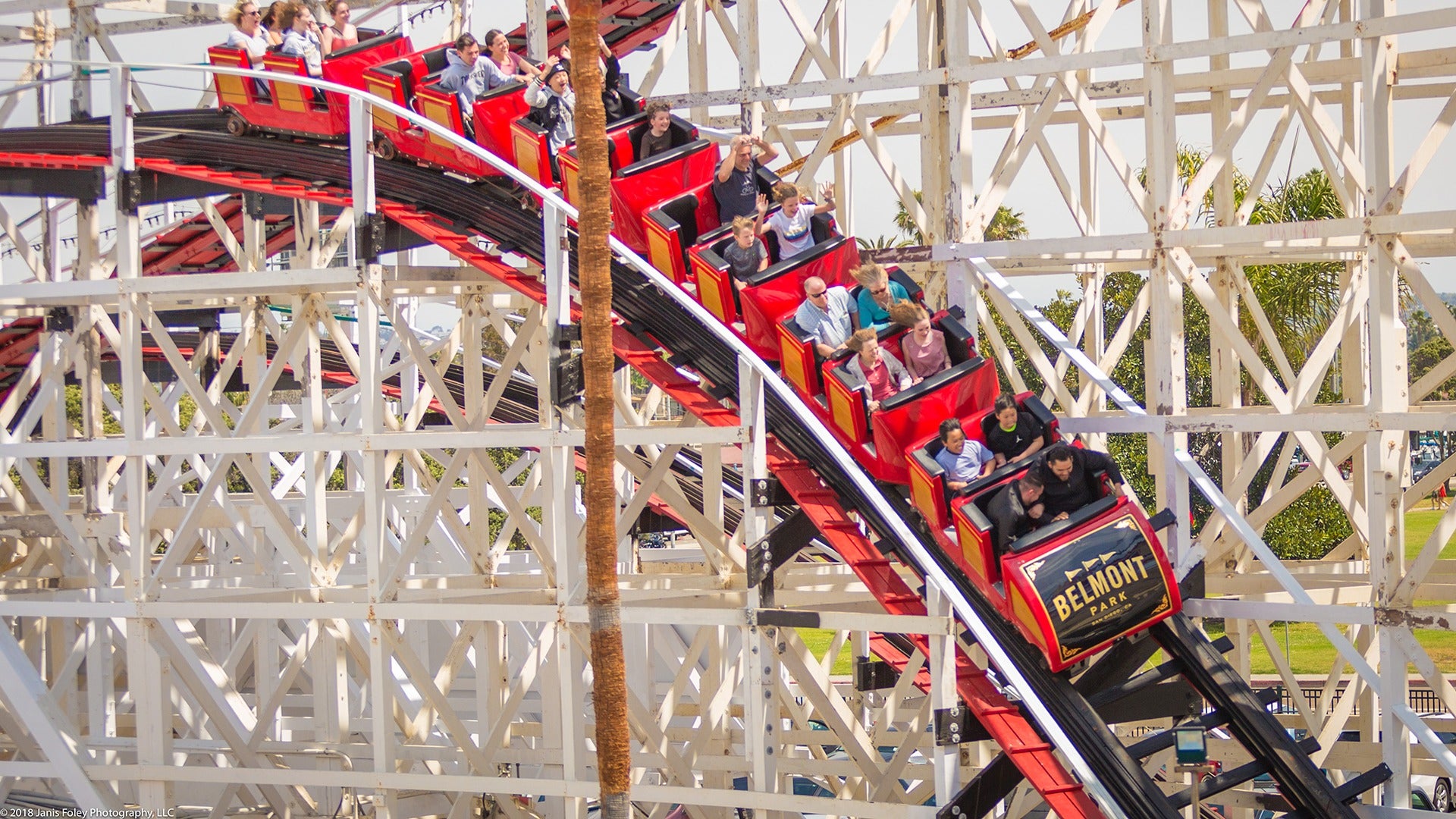 people riding a red roller coaster