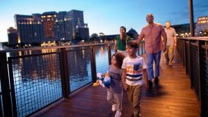 a family walking along a bridge with a building behind them