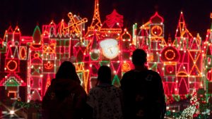 three people staring at holiday lights