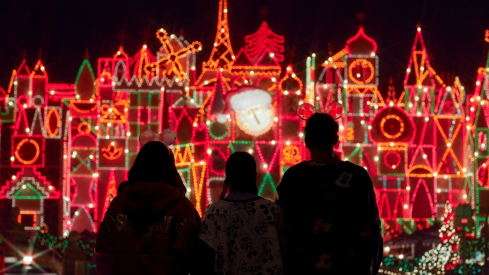 three people staring at holiday lights