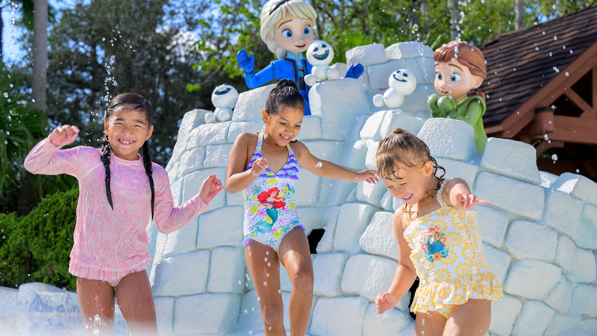 children having fun in a snow themed waterpark with ice castles behind them