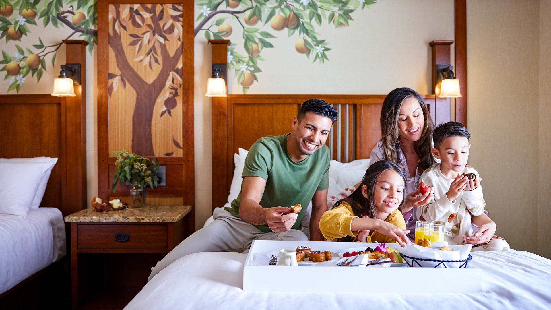 a family eating room serviced food in a hotel bed