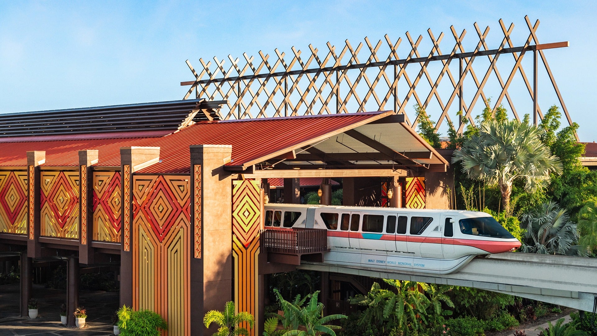 a train moving from the station, surrounded by trees and wooden roof spikes