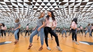 Guests posing inside a mirrored infinity room at Museum of Illusions Orlando with geometric reflections creating a kaleidoscope effect