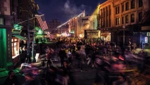 A packed Halloween Horror Nights scare zone at Universal Studios Hollywood with a marquee sign lit up at night