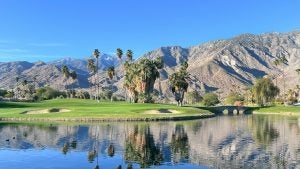 Golf course surrounded by dessert mountains under a blue sky