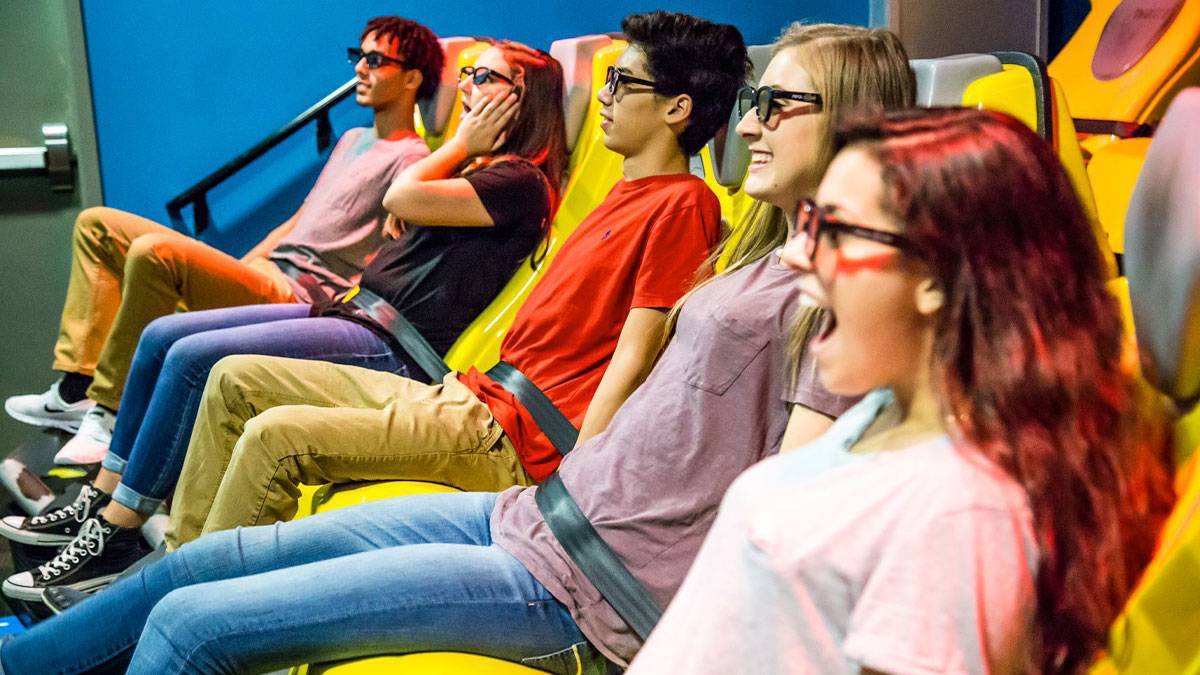 friends seated at theatre wearing glasses watching a film at 4D XD Motion Theater at Wonderworks in Branson, Missouri, USA
