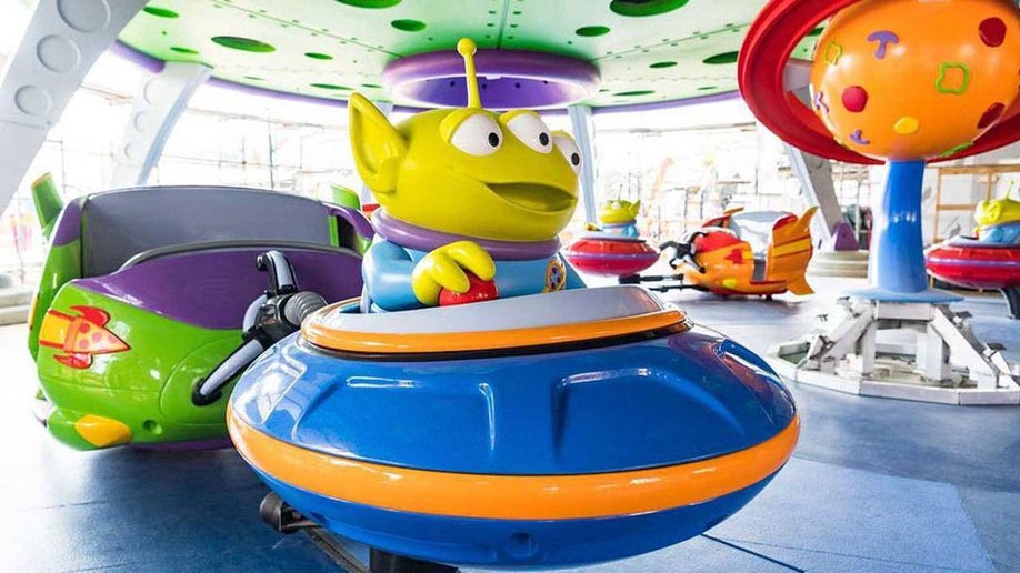 space shuttle with Alien character from Toy Story attached to seat of the Alien Swirling Saucers ride in Disneyworld, Orlando, Florida, USA