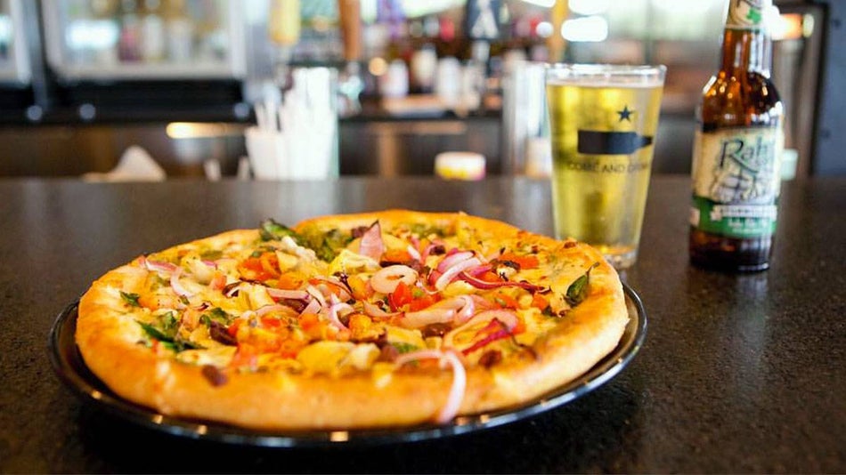 close up of pizza with glass and beer bottle in background at Austin Terrier in Austin, Texas, USA