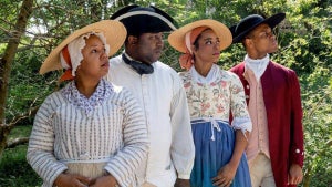 people in period clothing with plants and trees in background on sunny day at Black History Month at Colonial Williamsburg in Williamsburg, Virginia, USA