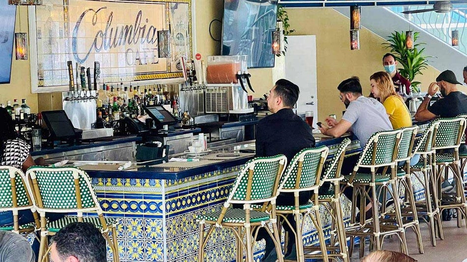 customers seated at the multicolored tile bar of Columbia Cafe waiting for their orders in Tampa, Florida, USA