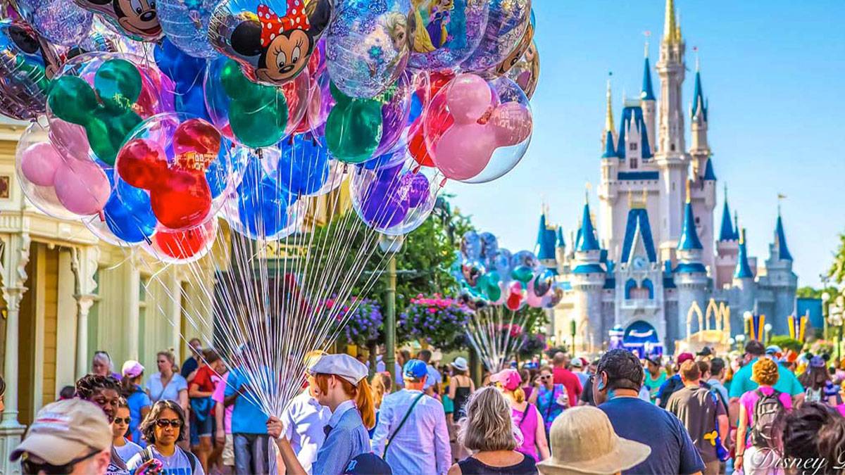   A distant view of a Disney world filled with people and balloons