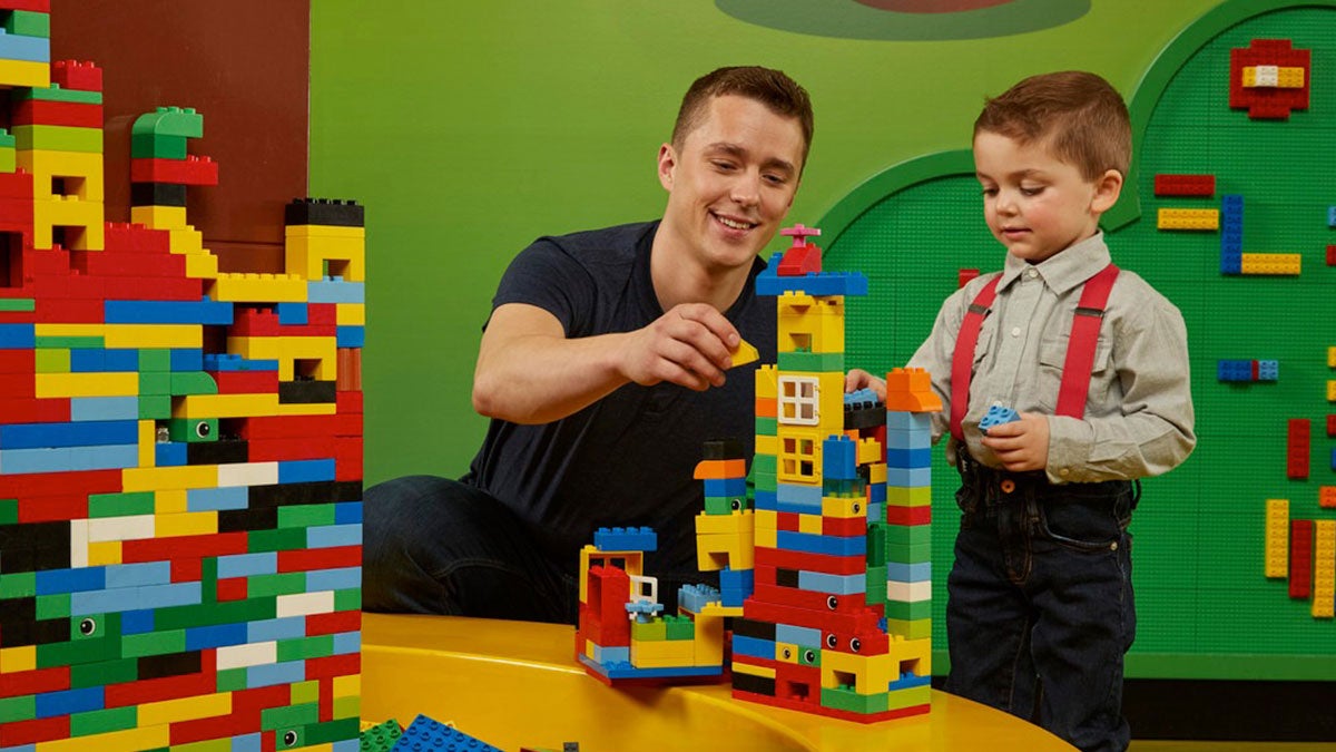 father and son building structure with lego in Duplo Village at Legoland Discovery Center in Philadelphia, Pennsylvania, USA