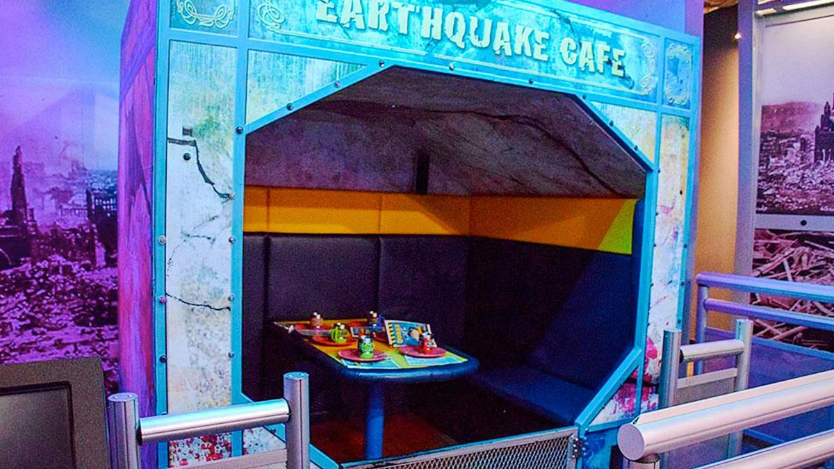 Earthquake Cafe ride in WonderWorks featuring booth chairs and table with fake plates of food in WonderWorks Orlando, Florida, USA