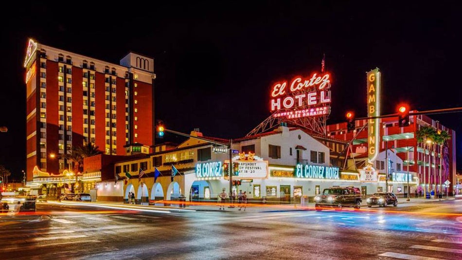 nightshot of El Cortez Hotel with cars passing by and people in the sidewalk in Las Vegas, Nevada, USA