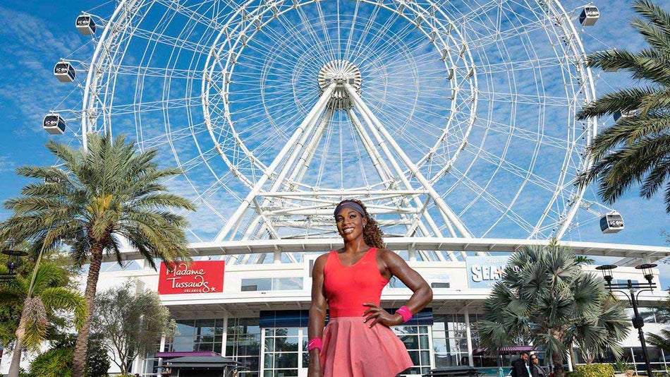 Entrance to Madame Tussauds Orlando with wax figure of Serena Williams in foreground and Ferris Wheel in background in Orlando, Florida, USA