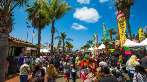 crowd on a sunny day with stalls and palm trees at Fiesta Old Town Cinco De Mayo in San Diego, California, USA