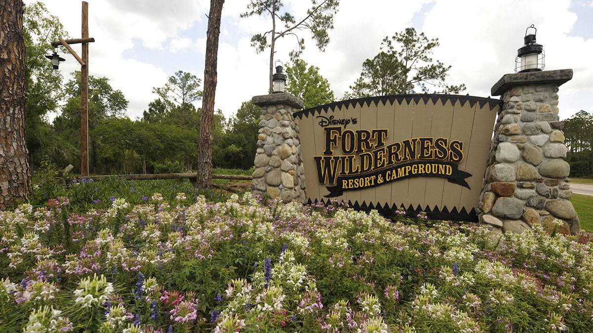 Disney Fort Wilderness Resort and Campground sign between cobblestone lampstands with bed of flowers in foreground in Florida, USA