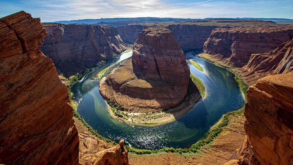 aerial view of rock formations and body of water during sunny day at Horeshoe Bend in Glen Canyon, Colorado-River, Arizona, USA