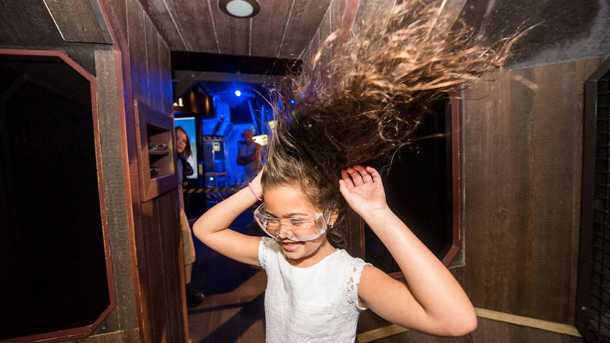   a picture of a child wearing eyeglasses while her hair is flying