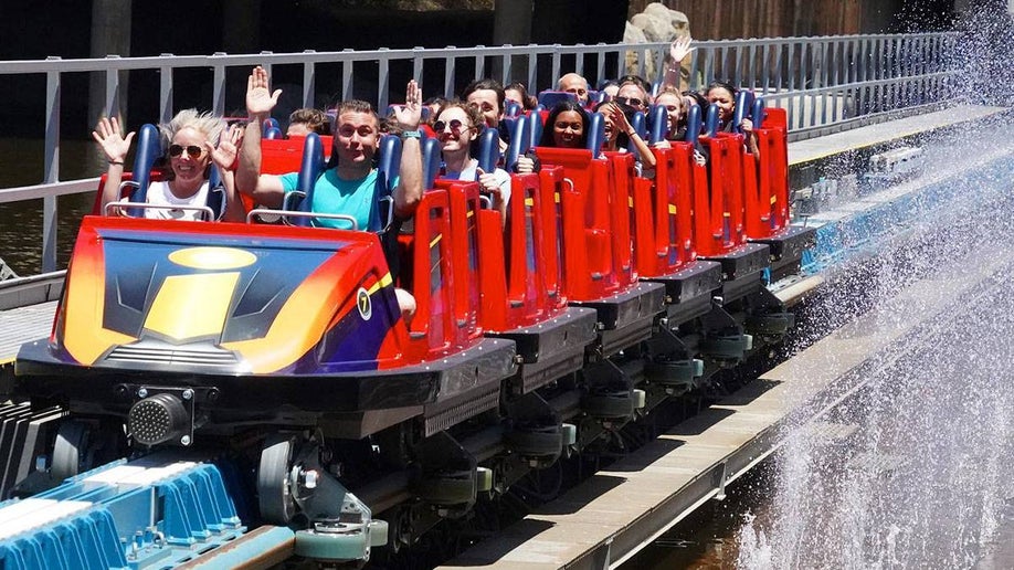 people aboard the Incredicoaster with water splasing at the side of the track in Disneyland, Anaheim, California, USA
