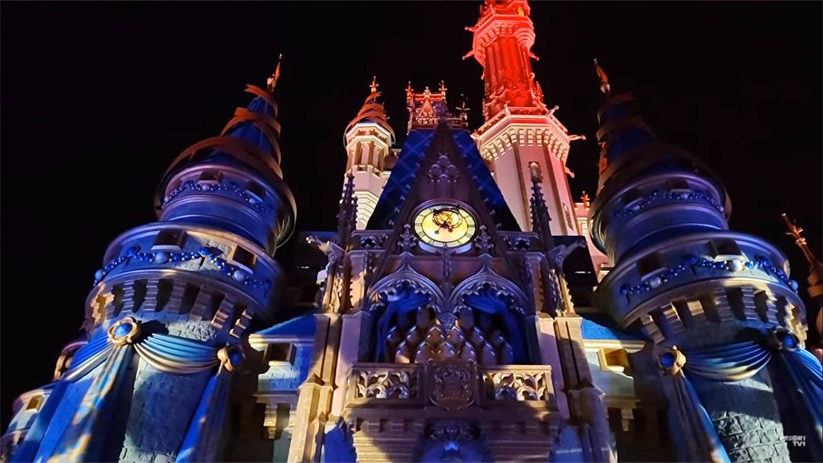 Disneyland castle lit up with blue and red lights for the Indepence Day Celebration at Disneyland Park