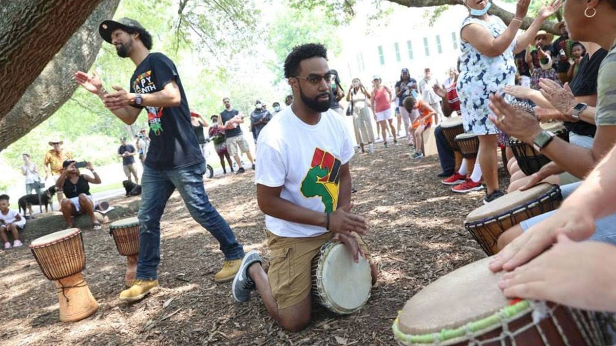 people playing drums and people dancing while crowd watches from behind for Juneteenth Celebration, Colonial Williamsburg Museum, Williamsburg, Virgnia, USA