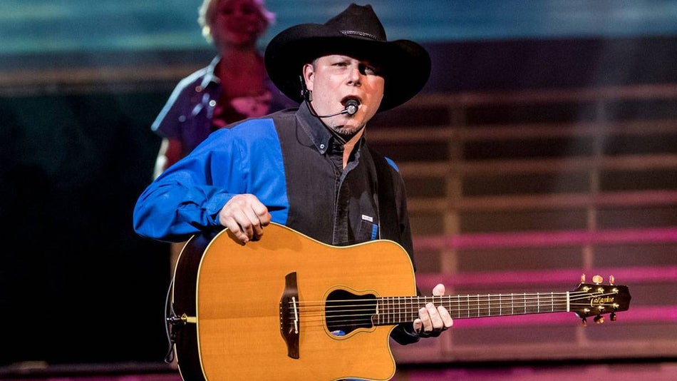 Garth Brooks impersonator performing onstage with guitar and back up singer at Legends of Country in Branson, Missouri, USA