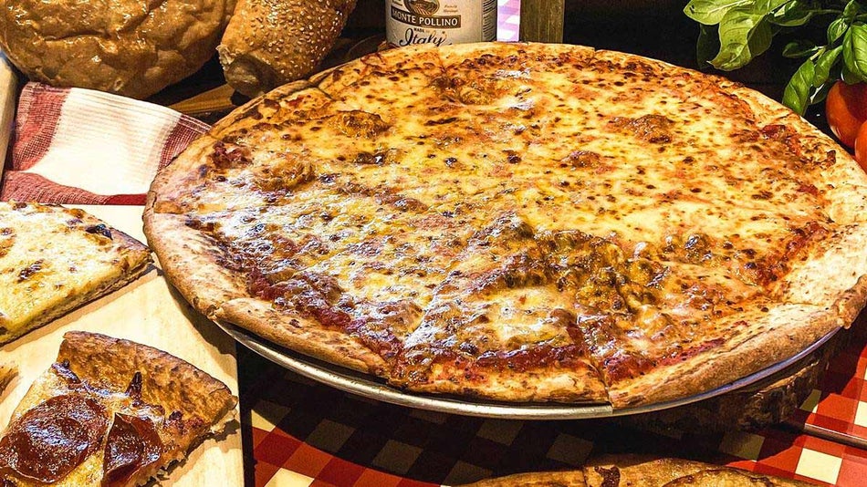 whole cheese pizza beside pepperoni pizza slices in Brickolini's Pizza & Pasta at Legoland New York in New York, USA