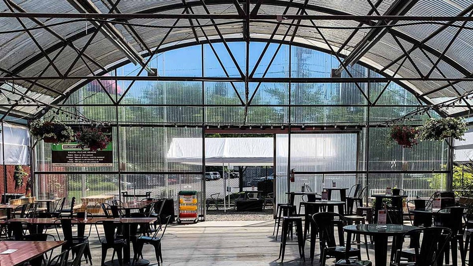 Outdoor Atrium with sunroof, table and chairs, and hanging plants at Level Beer in Portland, Oregon, USA