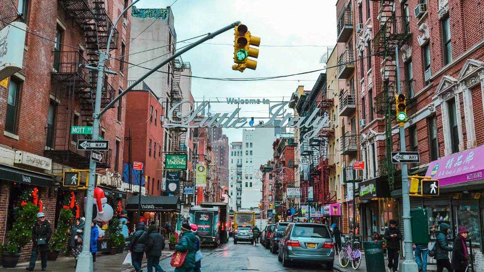 people and cars under the sign of Little Italy in Little Italy, Manhattan, New York City, USA