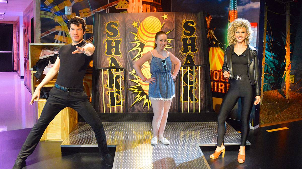 guest posing for photo between two wax figures at Madame Tussauds Orlando, Orlando, Florida, USA