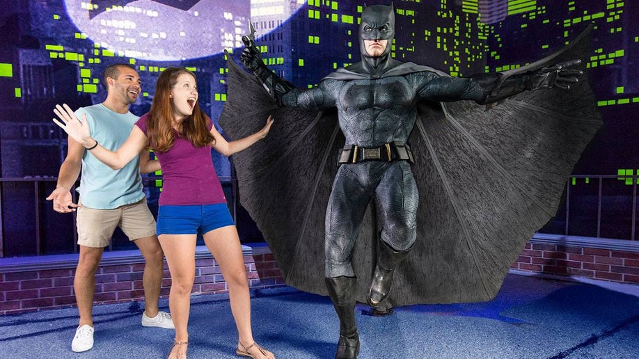 guests posing beside wax figure of Batman in Madame Tussauds