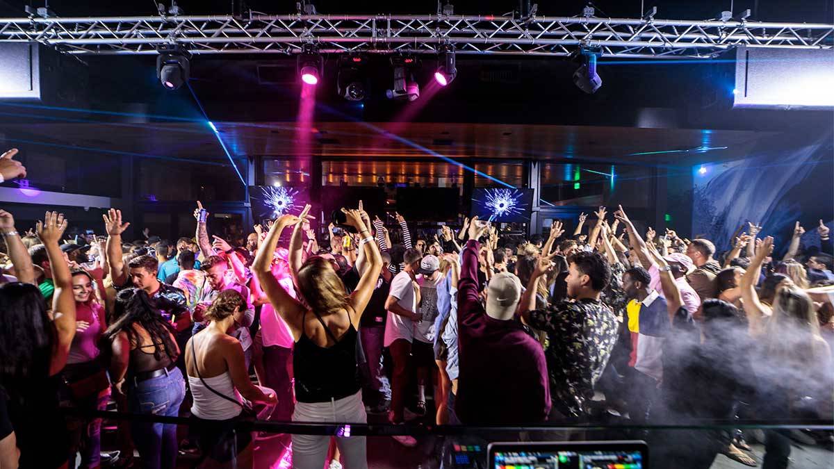 people dancing with colorful lights on ceiling at Mavericks Beach Club in San Diego, California, USA