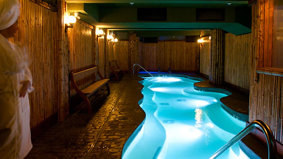 lighted blue Salt Water pool in room with bamboo covered walls in McMenamins Crystal Hotel, Portland, Oregon, USA