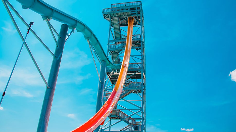 Mile High slide with person sliding down with blue sky in background in Kentucky Kingdom, Louisville, USA
