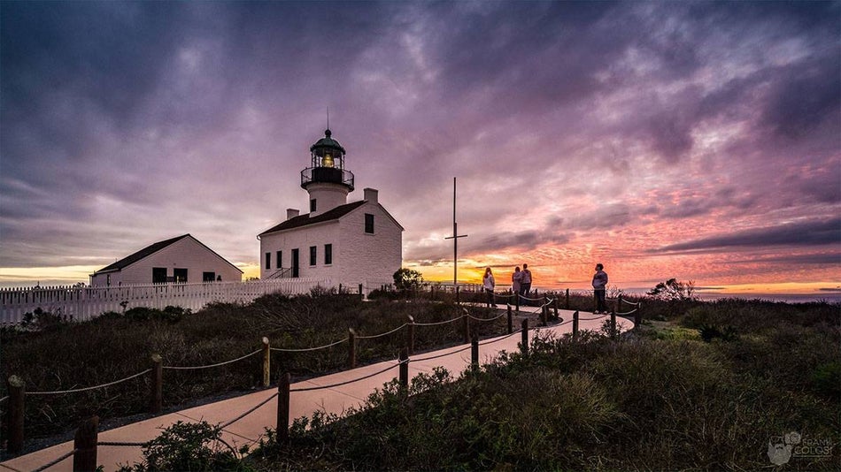 sunset with people walking in the path to Old Point Loma Lighthouse at San Diego Bay, San Diego, California, USA