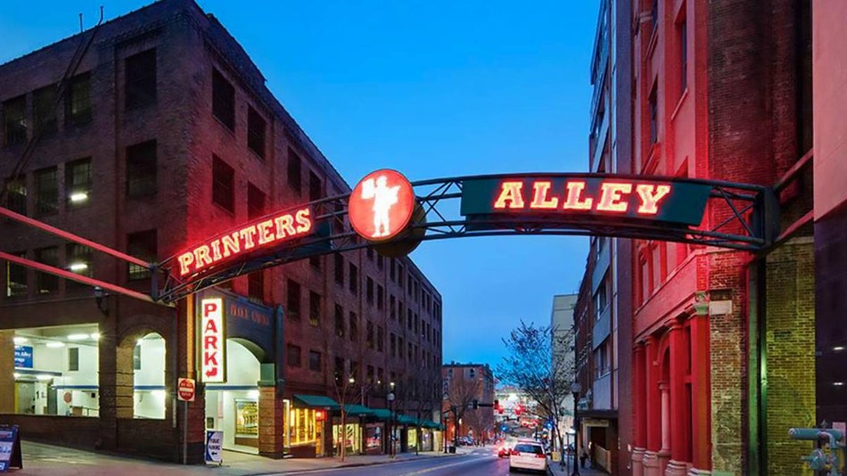 glowing Printer's Alley welcome sign between two buildings in Printer's Alley, Nashville, Tennessee, USA
