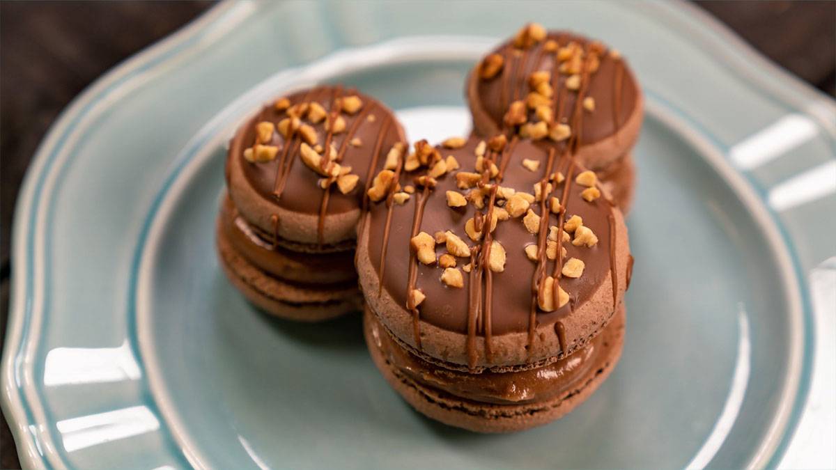chocolate caramel macaron shaped like the Mickey Mouse logo topped with peanuts and chocolate on a plate for the Food and Wine Festival at Disneyland, Anaheim, California, USA