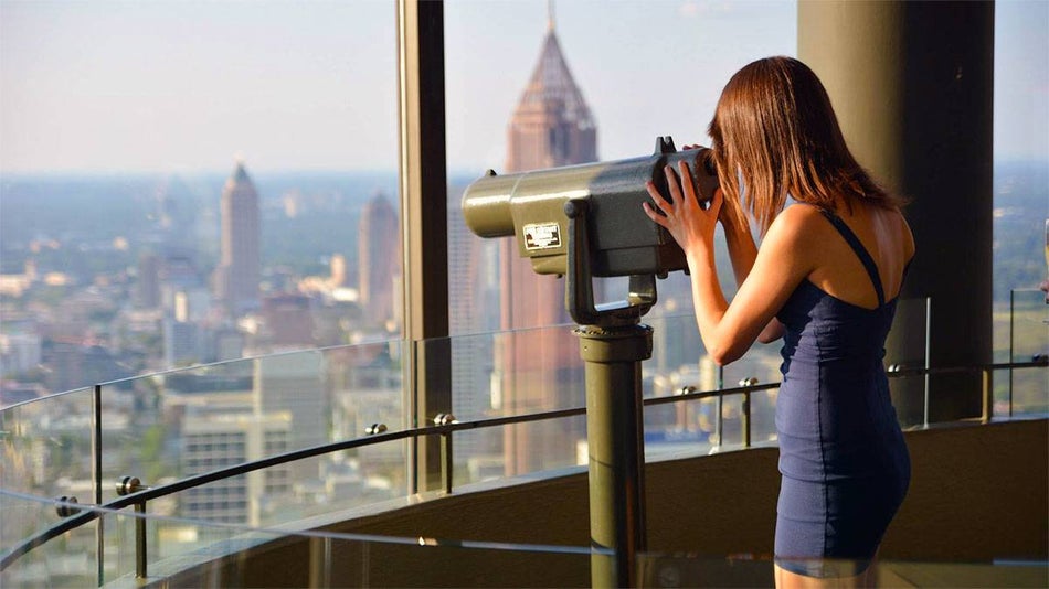 woman looking through tower viewer at Atlanta skyline at Sun Dial Observatory in Atlanta, Georgia, USA
