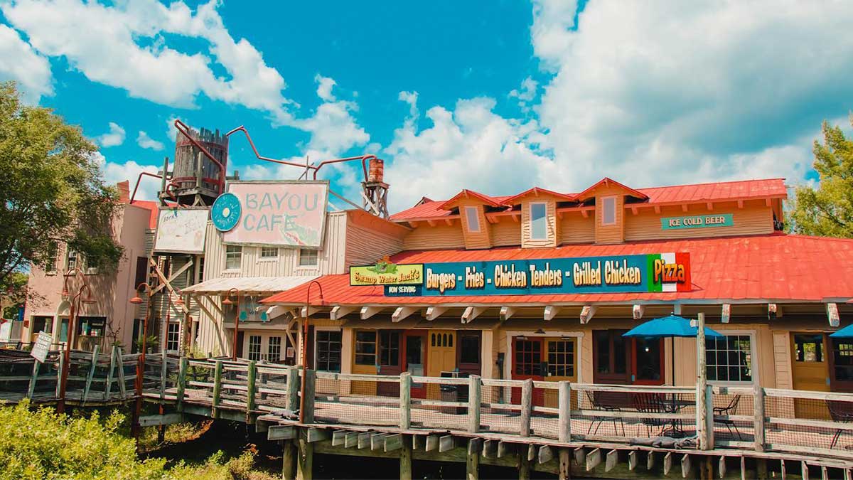 Exterior of Swamp Water Jack's Restaurant beside Bayou Cafe with blue sky and clouds in Kentucky Kingdom in Louisville, Kentucky, USA