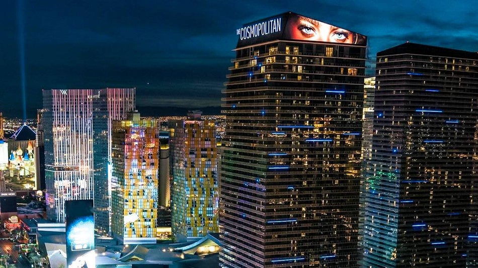 exterior of The Cosmopolitan Hotel with Las Vegas city scape in background at night in Las Vegas, Nevada, USA