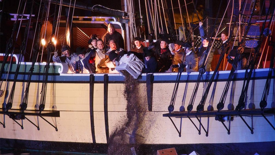 View of historical reenactment of tea being poured in the Boston Hard from a Boston Tea Party Ship in Boston, Massachusetts, USA