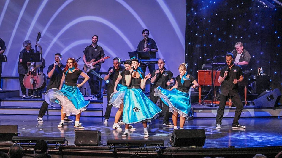 Wide shot of women in bright blue poodle skirts performing at the Hot Rods and High Heels show in Branson, Missouri, USA