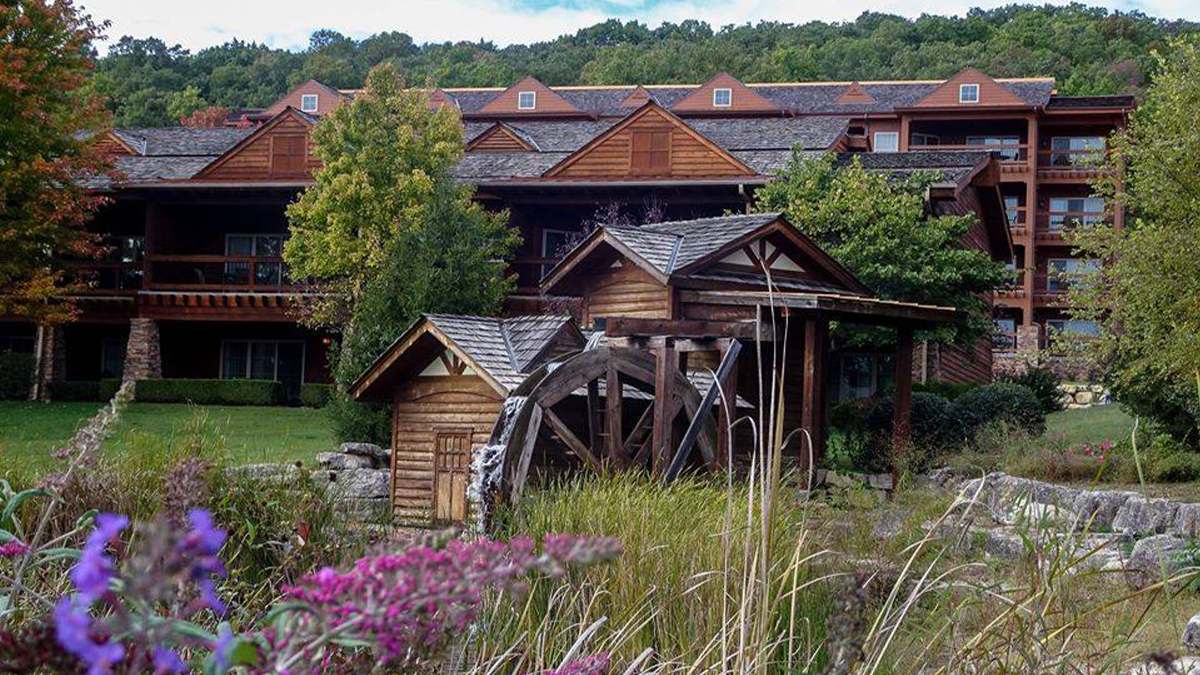 Wide shot of the Lodges at Timber Ridge, a large wooden log building, on a sunny day in Branson, Missouri, USA