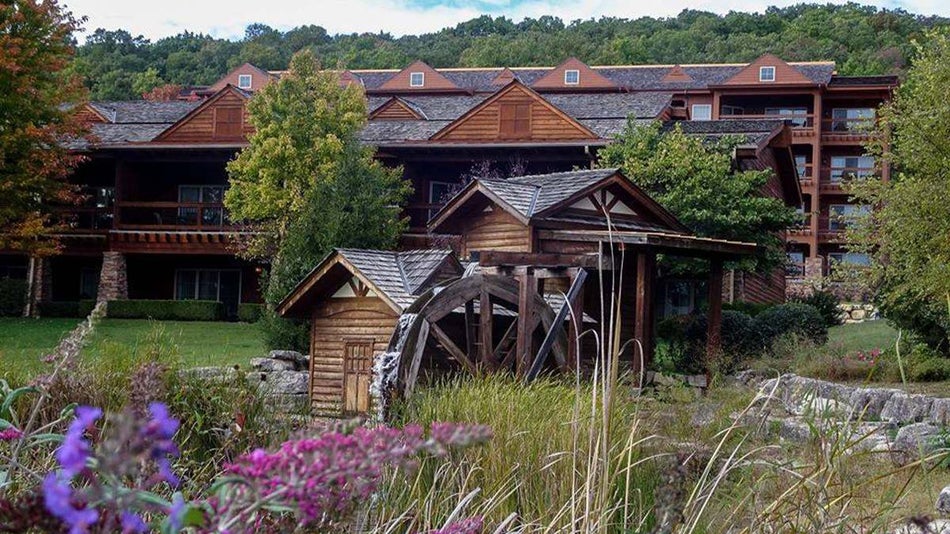 Wide shot of the Lodges at Timber Ridge, a large wooden log building, on a sunny day in Branson, Missouri, USA